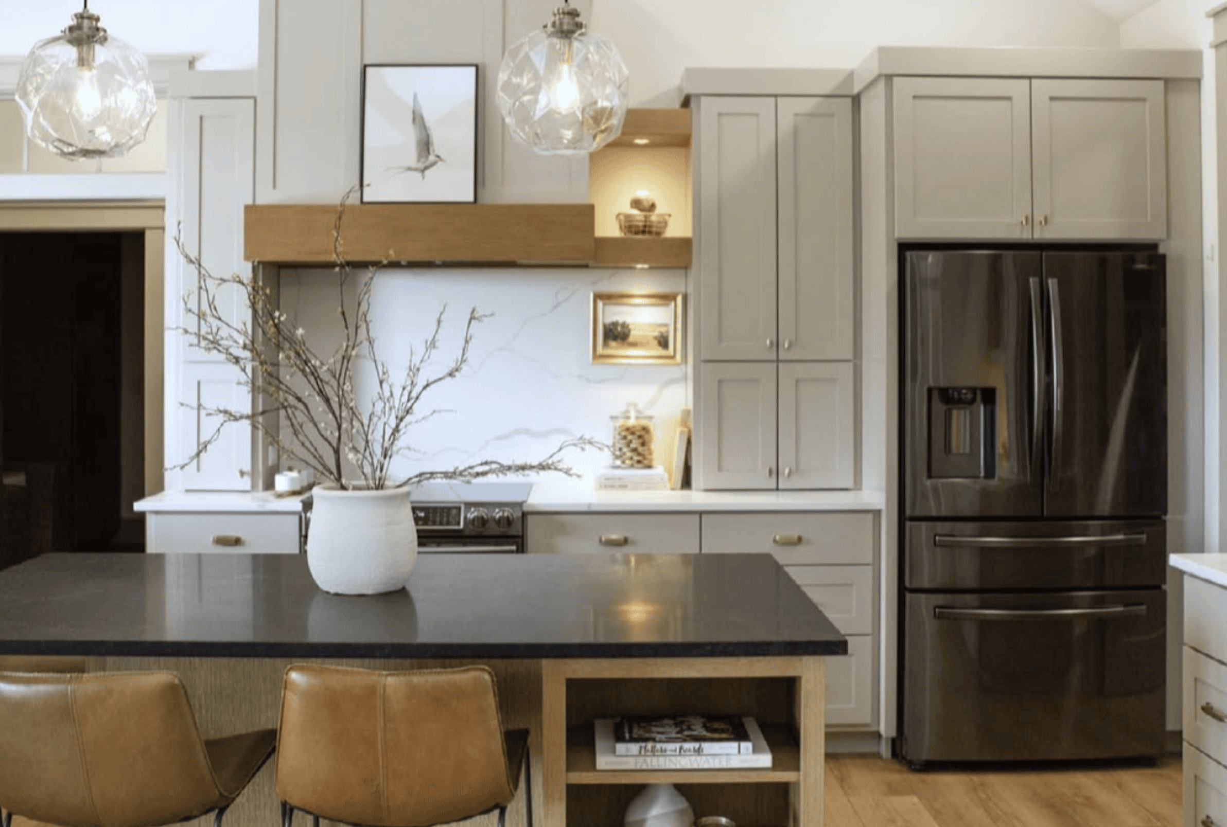 Kitchen interior featuring dark counter tops and gray and beige cabinets and accents.