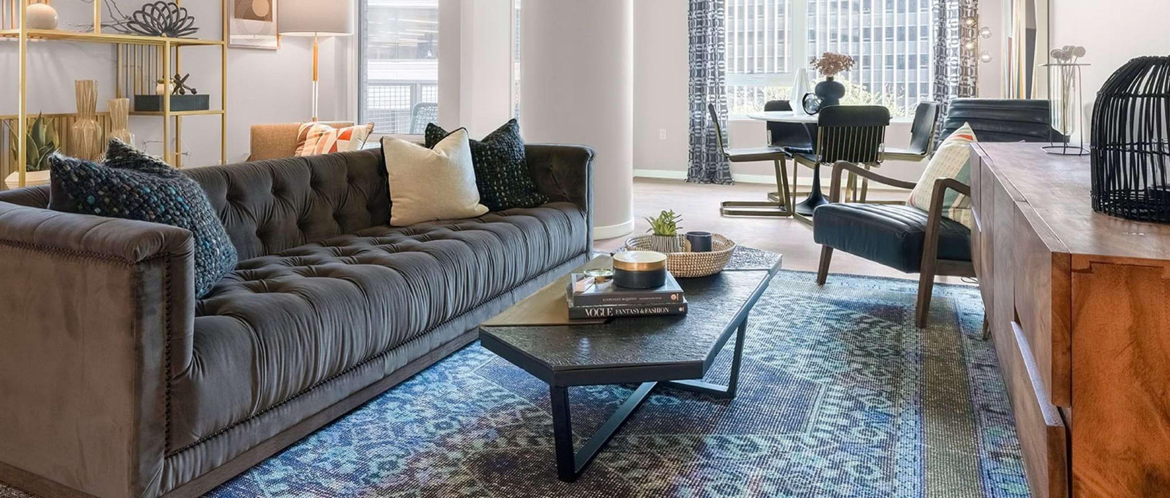 Shared space in a home with a couch, coffee table, and large rug.